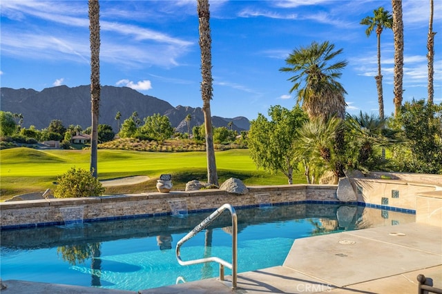 view of pool with a mountain view and a yard