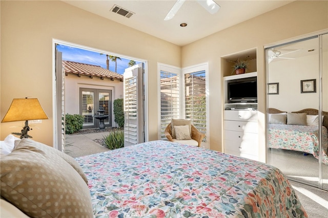 bedroom featuring multiple windows, light colored carpet, ceiling fan, and french doors