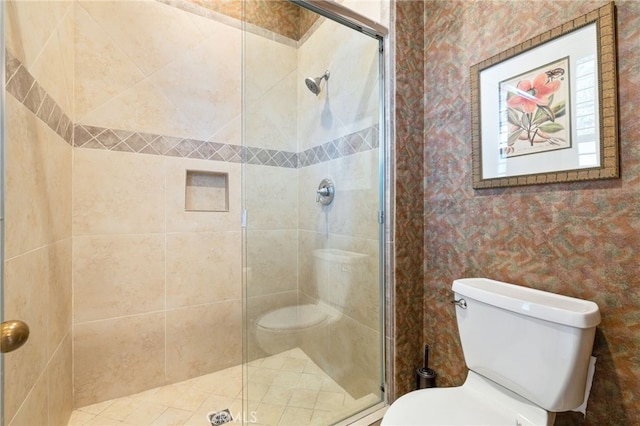 bathroom with a shower with shower door and toilet