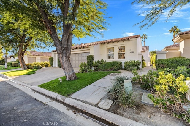 mediterranean / spanish home with a garage and a front yard