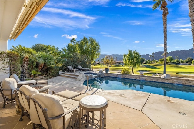 view of pool featuring a mountain view, a patio area, and a fire pit