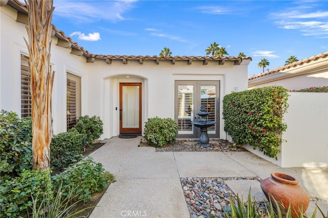 property entrance featuring a patio and french doors