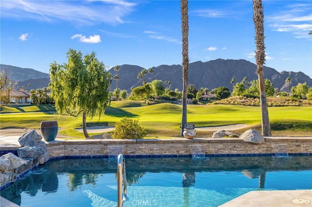 view of pool with a mountain view and a yard