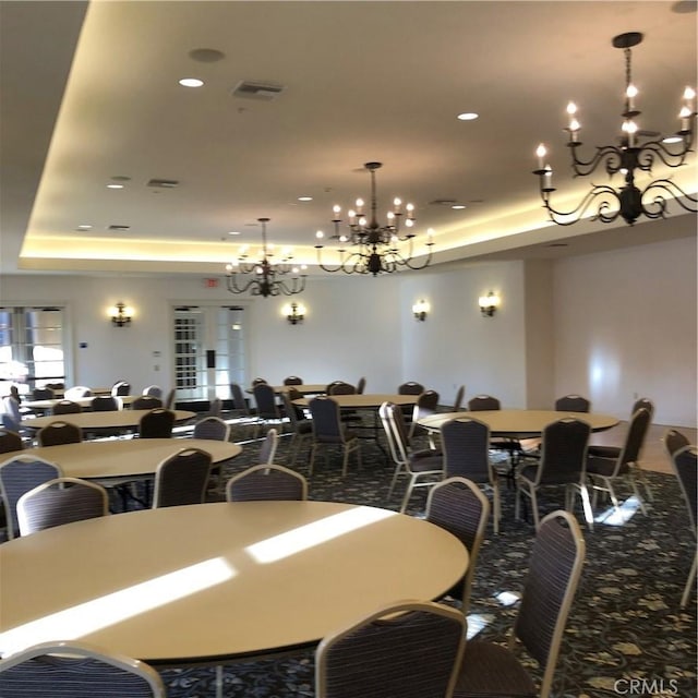 dining room featuring an inviting chandelier and a raised ceiling