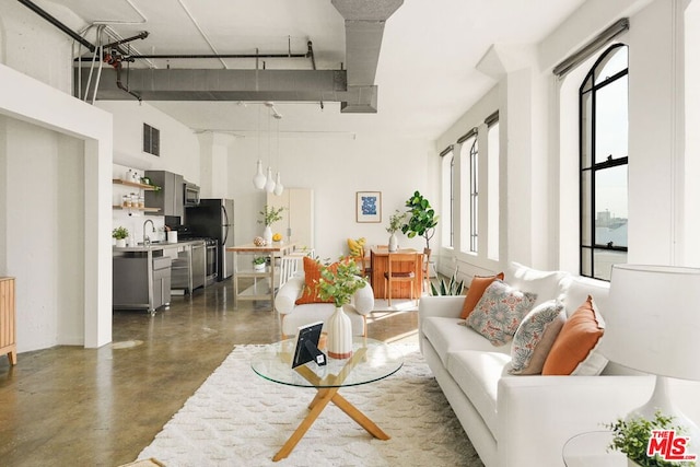 living room with sink, a wealth of natural light, and a high ceiling