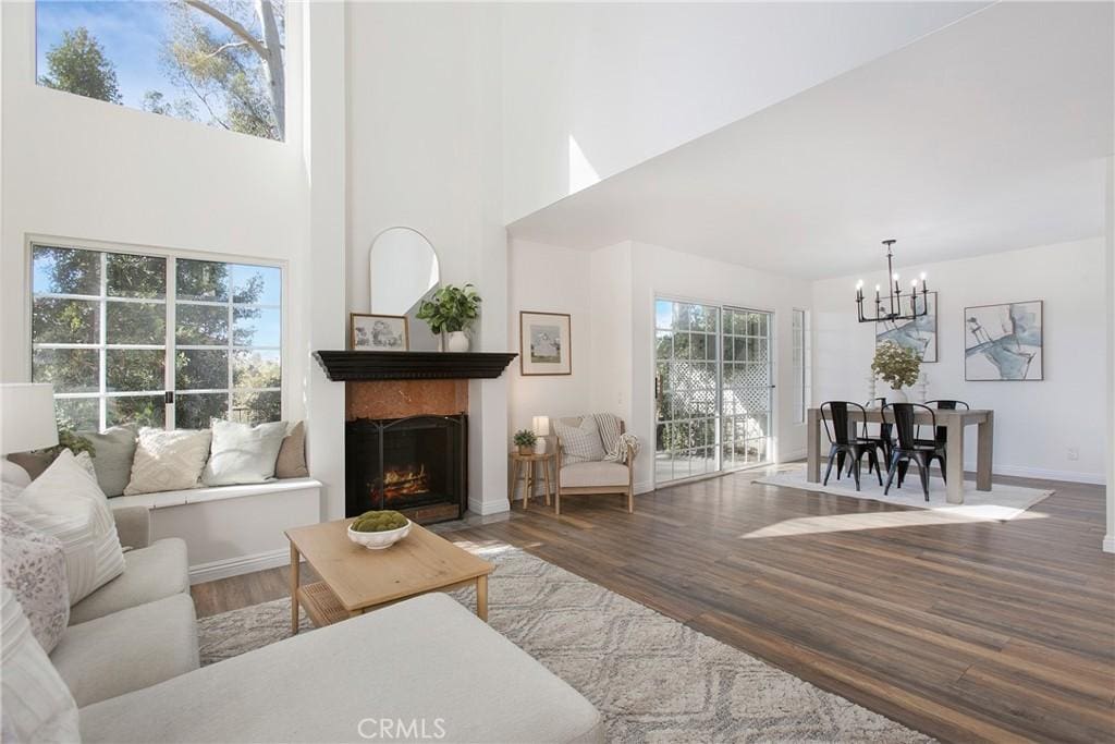 living room with hardwood / wood-style floors, a high ceiling, and a notable chandelier