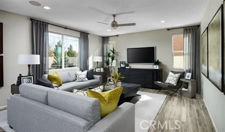 living room featuring ceiling fan and light hardwood / wood-style floors