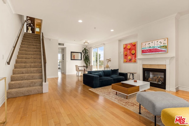 living room with crown molding and light wood-type flooring