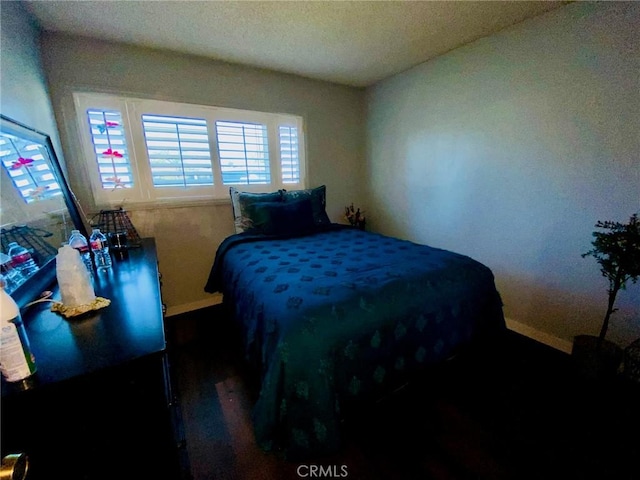 bedroom with dark hardwood / wood-style flooring and a textured ceiling