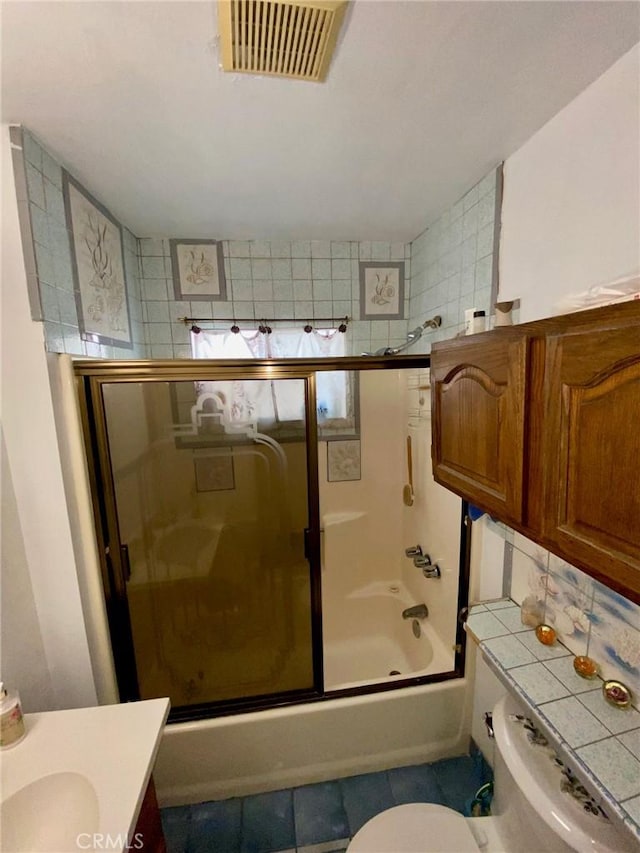 full bathroom with tile patterned flooring, vanity, toilet, and shower / bath combination with glass door