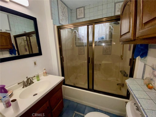 full bathroom with tile patterned floors, toilet, vanity, and combined bath / shower with glass door