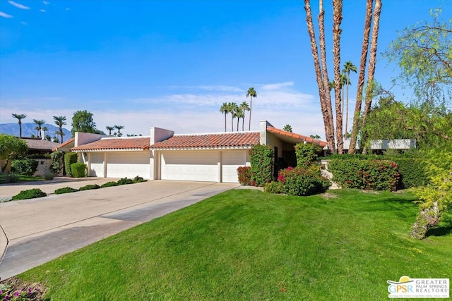 view of front of property featuring a garage and a front lawn