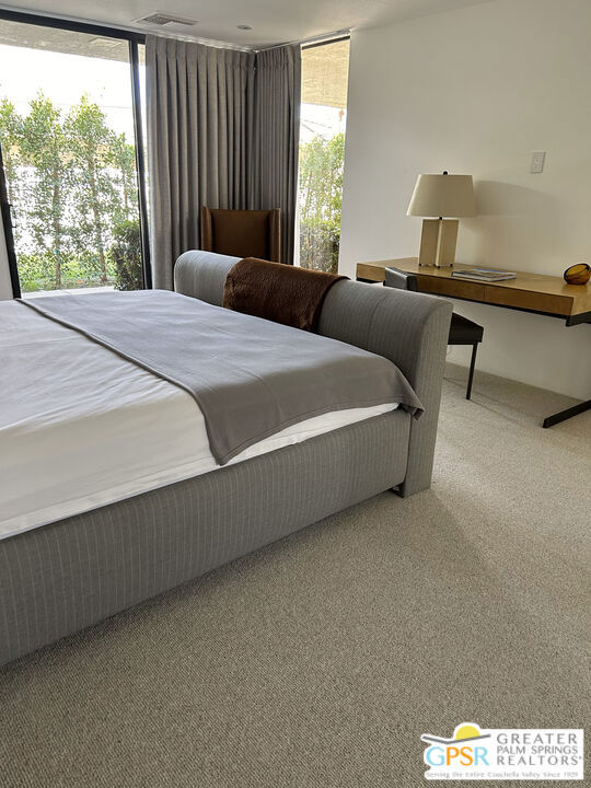 carpeted bedroom with floor to ceiling windows