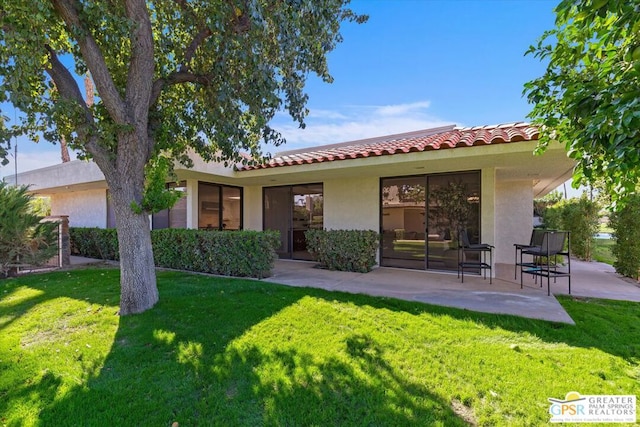 back of property with a patio and a lawn