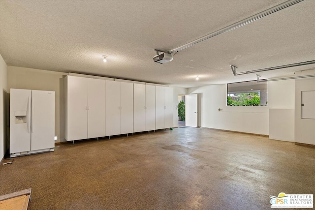 garage with a garage door opener and white refrigerator with ice dispenser