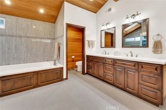 bathroom with vanity, lofted ceiling, toilet, a tub to relax in, and wood ceiling