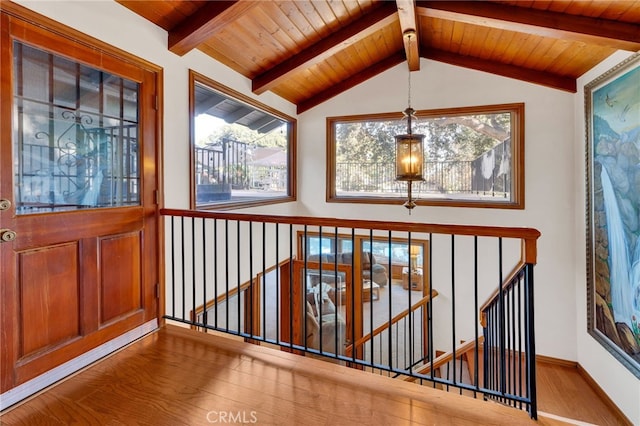 interior space with vaulted ceiling with beams, wood finished floors, wood ceiling, and baseboards