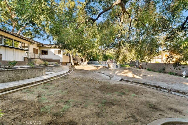 view of yard with fence and stairway