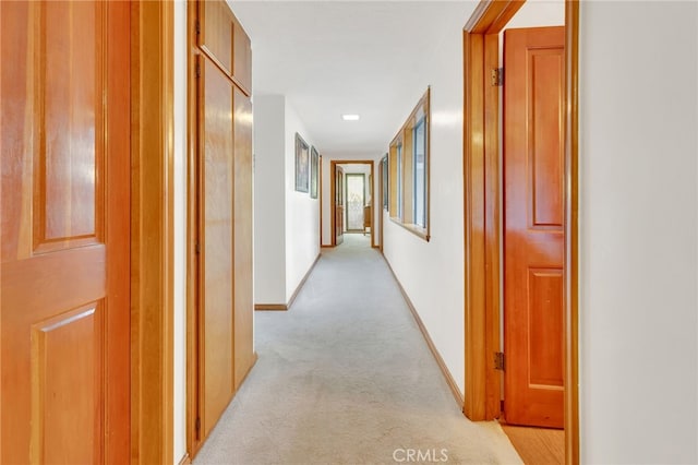 hallway featuring light colored carpet