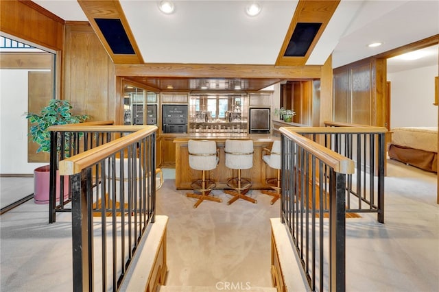 interior space with light countertops, recessed lighting, wooden walls, and light colored carpet