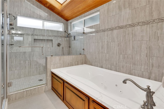 full bath with a jetted tub, lofted ceiling with skylight, a shower stall, and tile patterned flooring