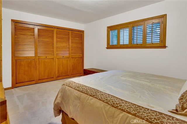 bedroom with a closet and light carpet