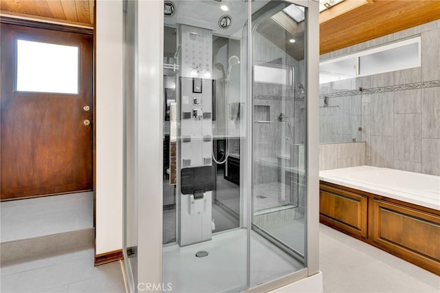 bathroom with separate shower and tub and tile patterned flooring