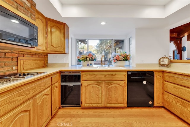 kitchen with stainless steel gas stovetop, sink, and light wood-type flooring