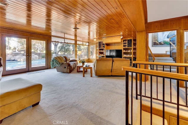 living room featuring wood ceiling, stairway, carpet flooring, french doors, and wood walls