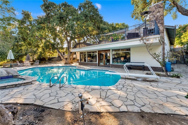 view of swimming pool featuring an in ground hot tub, a patio, central AC unit, and a diving board