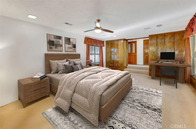 bedroom featuring light colored carpet, ceiling fan, and visible vents