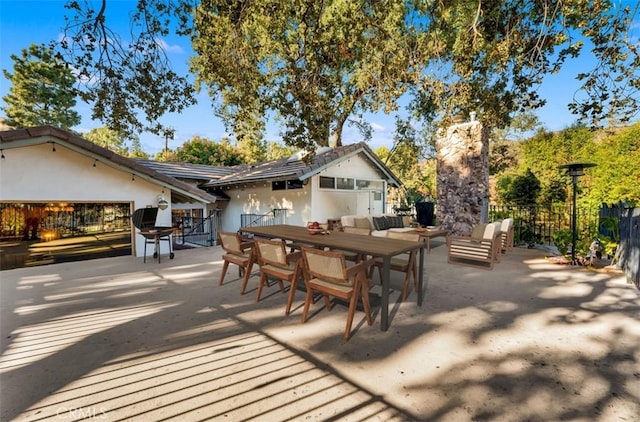 exterior space featuring a patio area, fence, stucco siding, and outdoor dining space