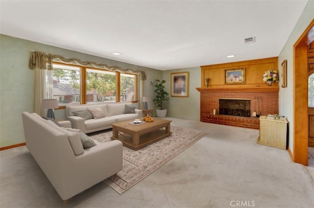 living area with light carpet, a brick fireplace, and visible vents