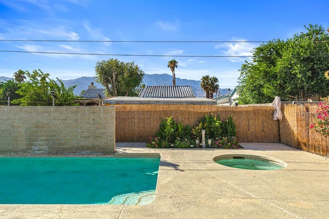 view of swimming pool featuring a mountain view and an in ground hot tub