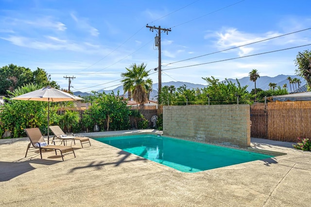 view of swimming pool featuring a mountain view and a patio