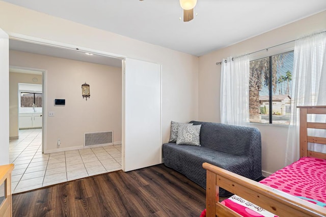 bedroom with multiple windows, wood-type flooring, and ceiling fan