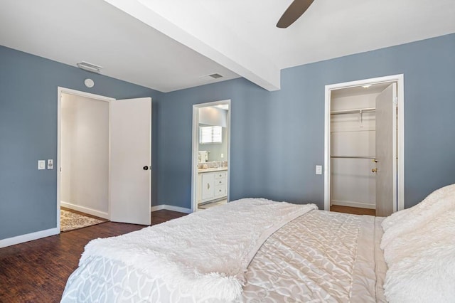 bedroom with ceiling fan, a spacious closet, connected bathroom, dark hardwood / wood-style floors, and a closet