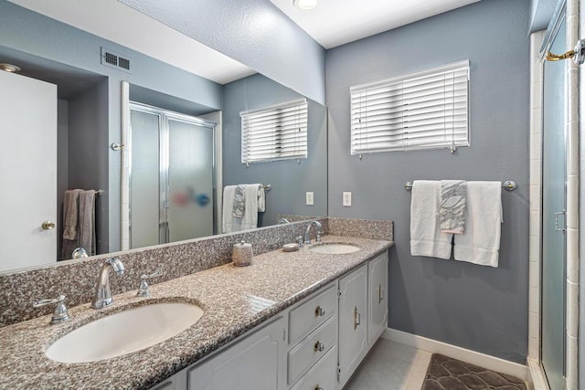 bathroom featuring tile patterned floors, vanity, and a shower with shower door