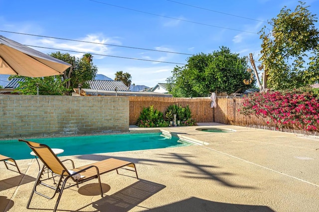 view of swimming pool featuring a patio area and an in ground hot tub