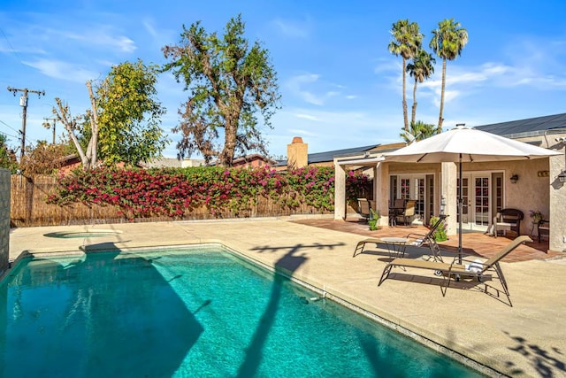 view of swimming pool with an in ground hot tub, a patio, and french doors