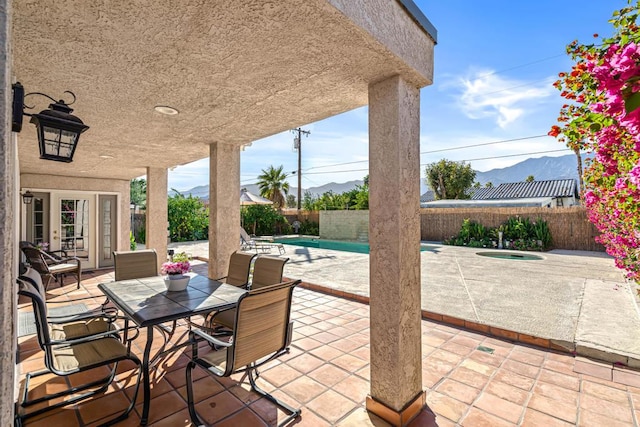 view of patio / terrace featuring a fenced in pool, a mountain view, and french doors