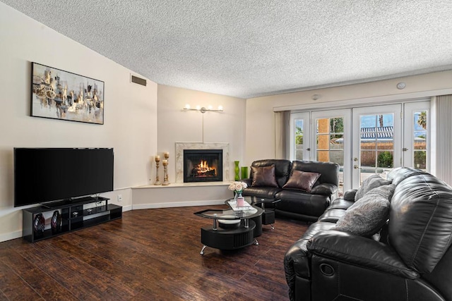 living room with dark hardwood / wood-style flooring, a textured ceiling, and french doors