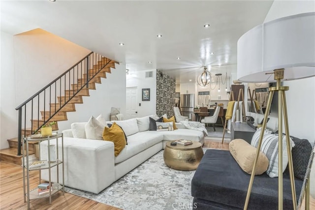 living room with hardwood / wood-style flooring and a notable chandelier