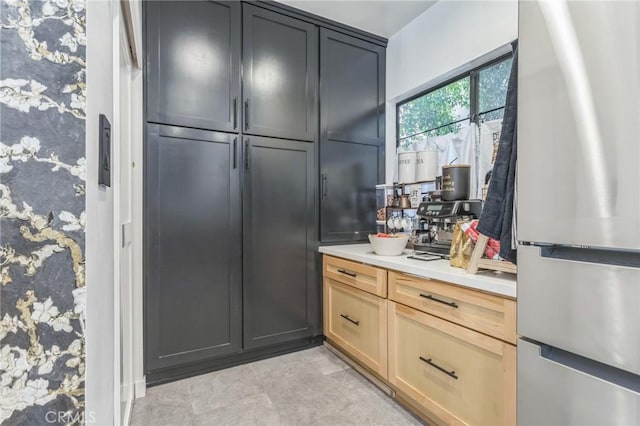 kitchen featuring light brown cabinets and stainless steel refrigerator