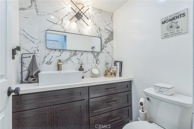 bathroom with vanity, tasteful backsplash, and toilet