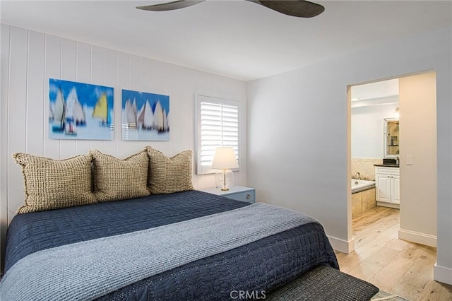 bedroom featuring ceiling fan, ensuite bathroom, and light wood-type flooring