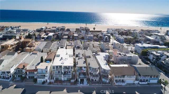 birds eye view of property with a water view and a beach view