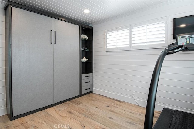 interior space featuring light wood-type flooring and wooden walls