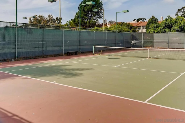 view of tennis court featuring basketball hoop