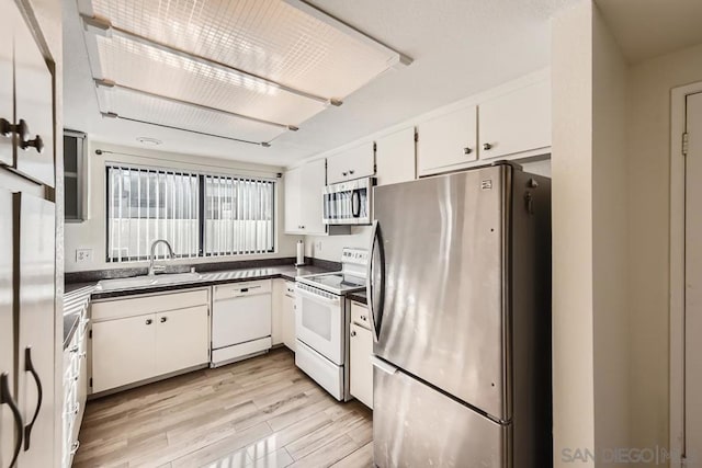 kitchen featuring white cabinetry, sink, light wood-type flooring, and appliances with stainless steel finishes